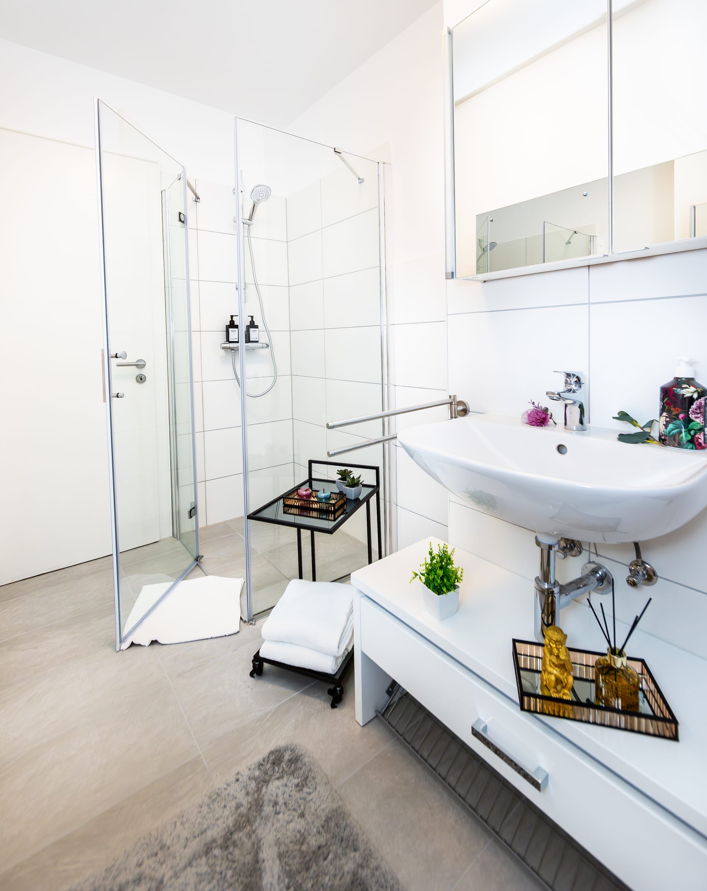 Bad mit Glasdusche, breitem Waschbecken und Spiegelschrank