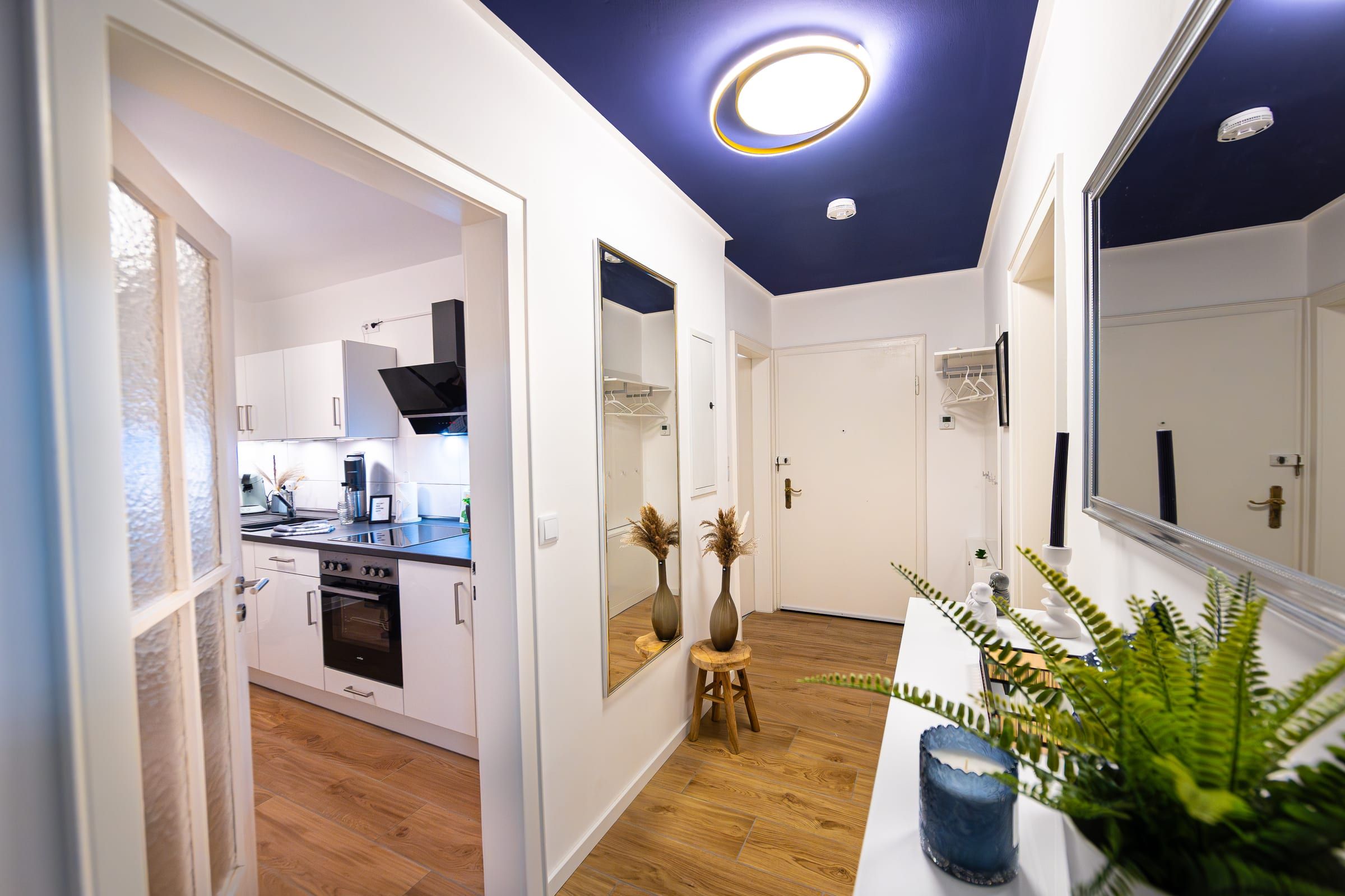 Flur mit dunkelblauer Decke, Blick durch die Glastür in die Küche und zur Wohnungstür